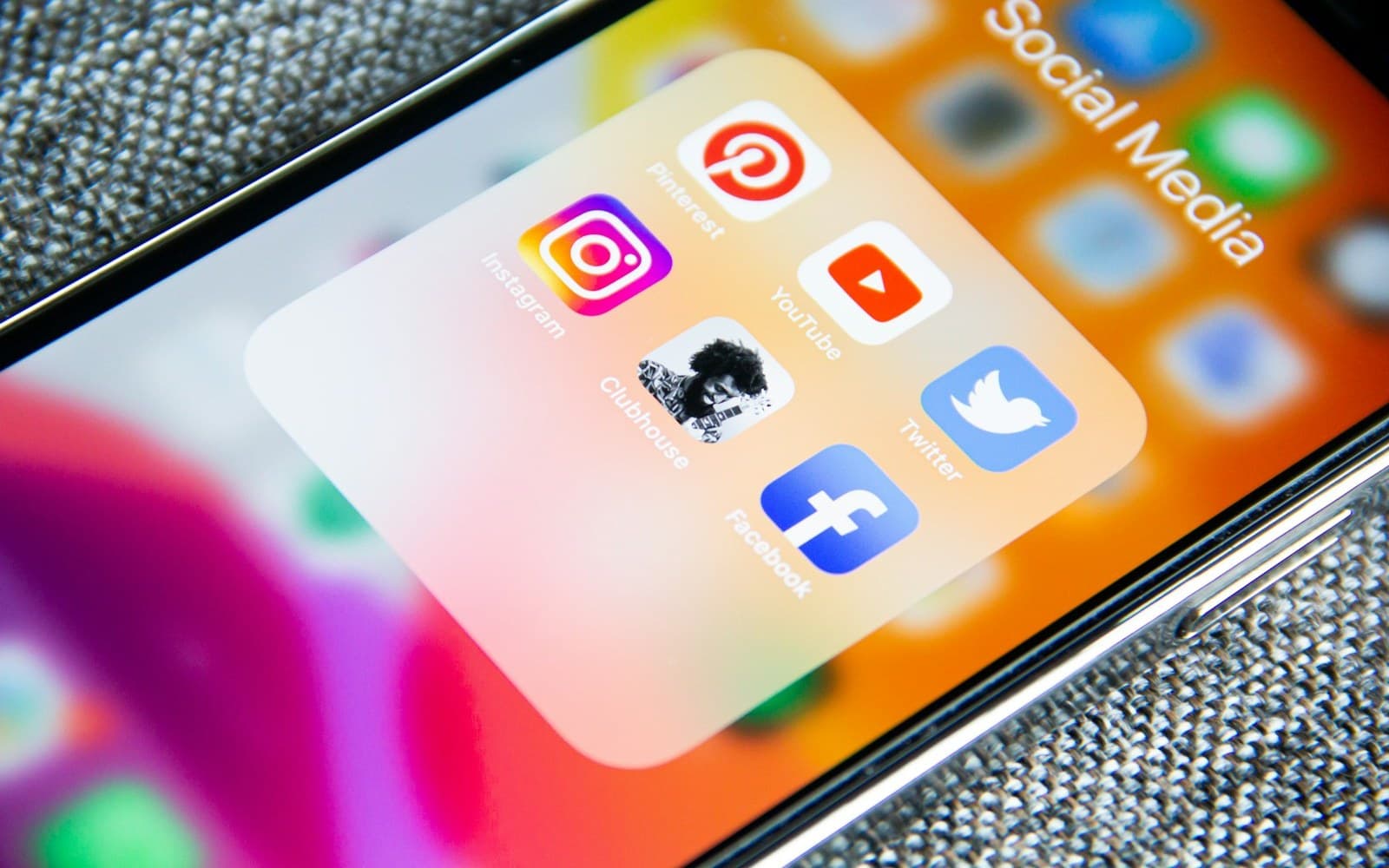 Persona sujetando un móvil mostrando la pantalla de búsqueda de una red social con resultados de negocios locales